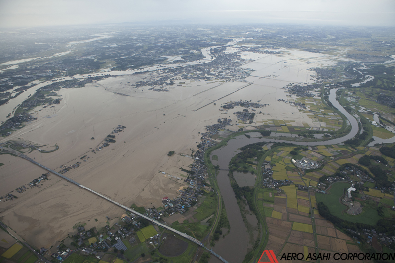 【常総市石下下流左岸　氾濫状況　左岸下流側より】画面中央左上が破堤箇所、中央上部が石下市街地である。破堤箇所よりも上流から氾濫しているが、これは石下市街地上流の左岸側にみられる越流氾濫の影響も含まれている。