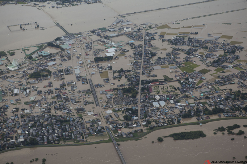 【常総市石下地区　浸水状況　右岸側より】画面中央やや左を上下に貫く道路が県道24号であり、下端の橋梁が石下大橋である。市街地はほぼ全域浸水している。